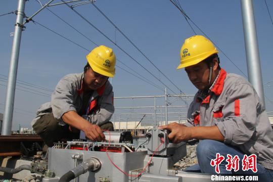 2013年6月18日，高丰华(右)正在对道岔电机进行电器特性测试。　中铁四局供图 摄